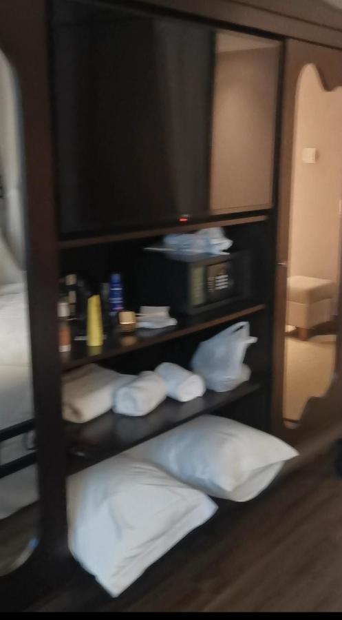 Hotel Buona Vitta Gramado by Gramado Parks Esterno foto The photo shows a piece of furniture, likely a shelving unit or cabinet, with several items on it. There is a television mounted on top. Below the TV, there is a microwave and a small safe. The shelves contain various toiletries and personal care pro