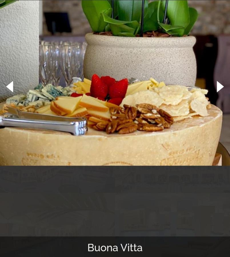 Hotel Buona Vitta Gramado by Gramado Parks Esterno foto The photo displays a beautiful cheese platter. It features a large round cheese wheel as the base, surrounded by various types of cheeses including soft and hard varieties. There are also some crackers or crisps, along with nuts, particularly pecans.