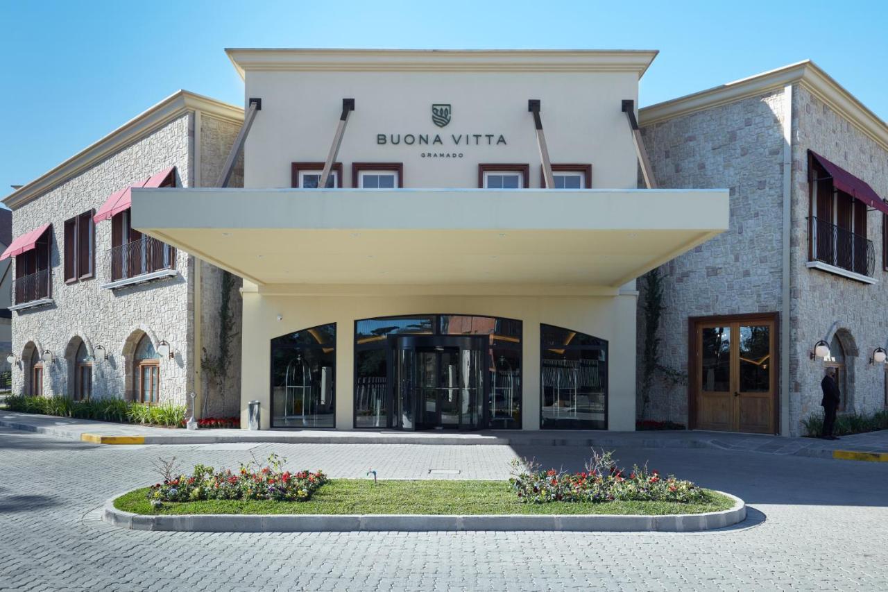 Hotel Buona Vitta Gramado by Gramado Parks Esterno foto The photo shows a modern building with a prominent entrance marked by a large awning. The facade features a mix of stone and stucco materials, giving it an elegant and contemporary look. The name "BUONA VITTA" is displayed prominently above the entra