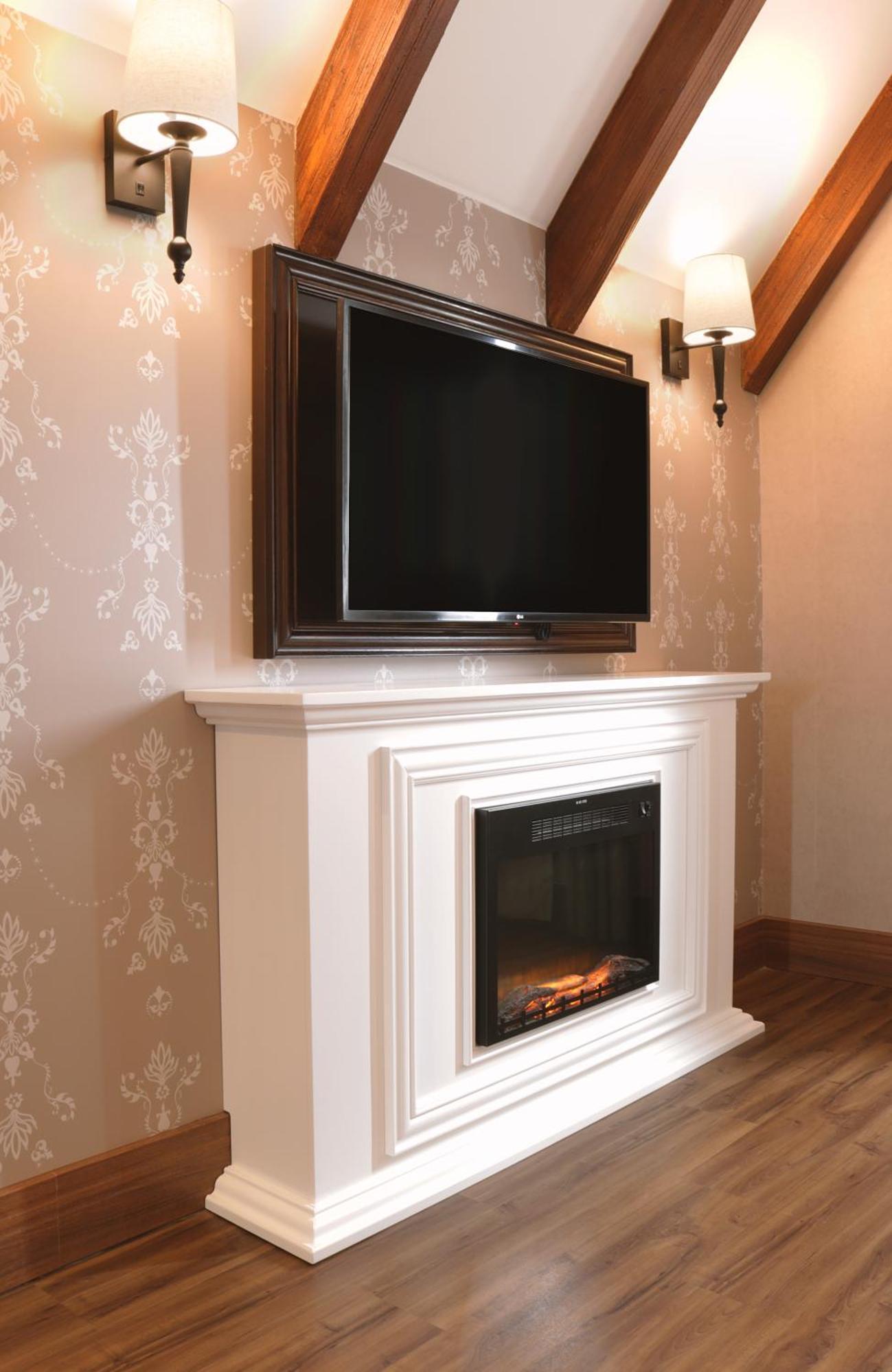 Hotel Buona Vitta Gramado by Gramado Parks Esterno foto The image shows a modern living room setup featuring a white mantel with an electric fireplace. Above the mantel, there is a large flat-screen television mounted on the wall. The fireplace has a glass front and displays a realistic flame effect, crea